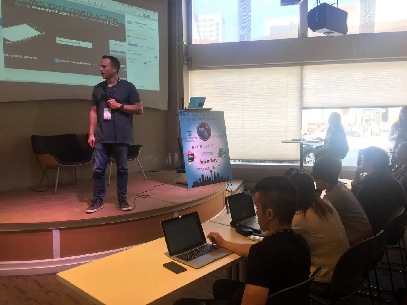 Brian Vinci presenting on stage at a startup event while coaching founders